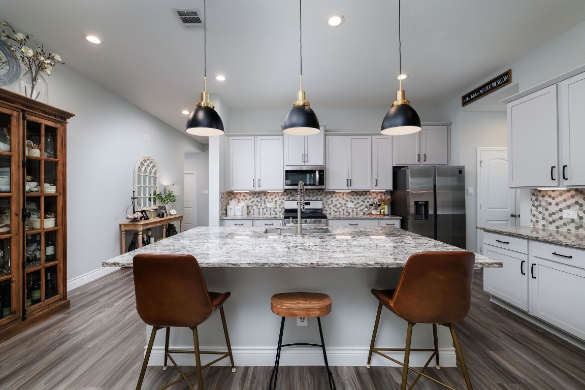 1507 Oakdale Crest Road Montgomery, TX 77316 - Photo 5 of 23 a kitchen with stainless steel appliances granite countertop a sink a stove a refrigerator cabinets and chairs