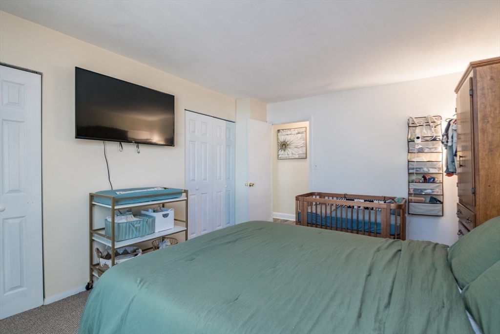 244 Nassau Drive, Unit 244 Springfield, MA 01129 - Photo 14 of 17 a bedroom with a bed and flat screen tv