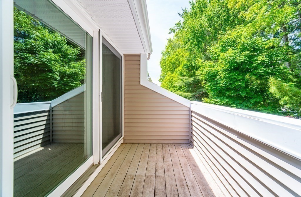 244 Nassau Drive, Unit 244 Springfield, MA 01129 - Photo 16 of 17 a view of a balcony with wooden floor and fence and a floor to ceiling window