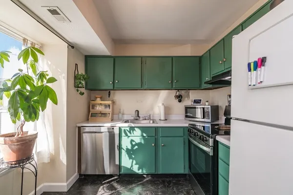 a kitchen with kitchen island a sink a stove and a refrigerator