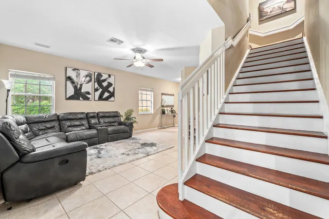 a living room with furniture and stairs