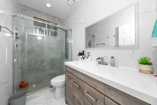 a bathroom with a sink a toilet and a shower