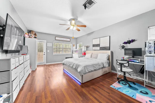 a spacious bedroom with a bed and a flat screen tv