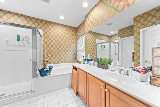 a spacious bathroom with a double vanity sink a mirror and a bathtub