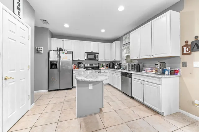 a kitchen with stainless steel appliances granite countertop a refrigerator sink and cabinets