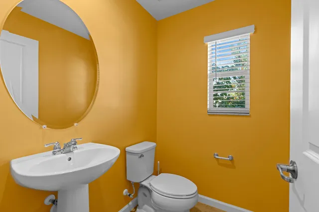 a bathroom with a sink mirror and toilet