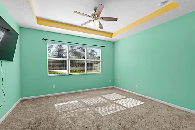 a view of empty room with window and ceiling fan