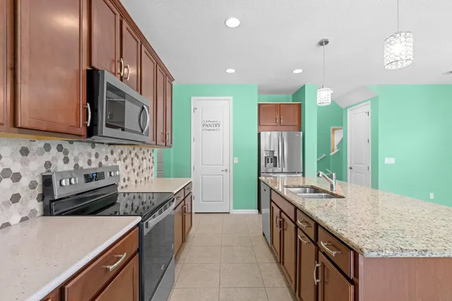 a kitchen with granite countertop a sink and a stove