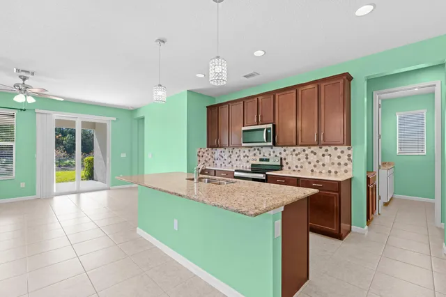 a large kitchen with kitchen island granite countertop a sink and a stove top oven