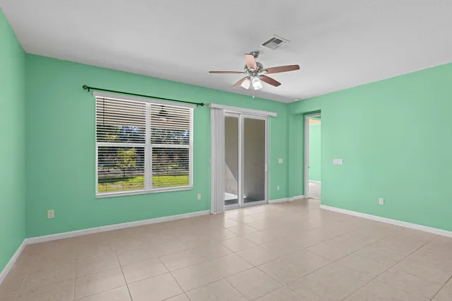 a view of an empty room with a window and a ceiling fan