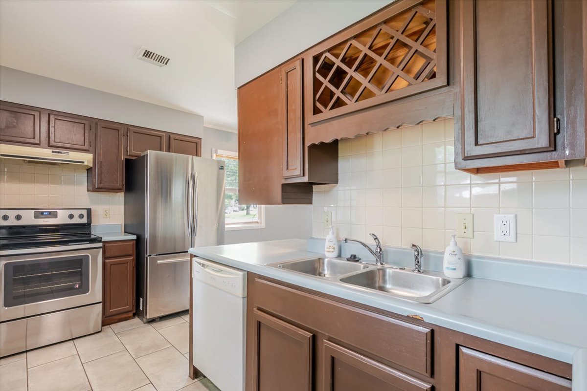 307 Meadows Avenue Bloomington, IL 61701 - Photo 7 of 15 a kitchen with stainless steel appliances granite countertop a sink a stove a refrigerator and cabinets