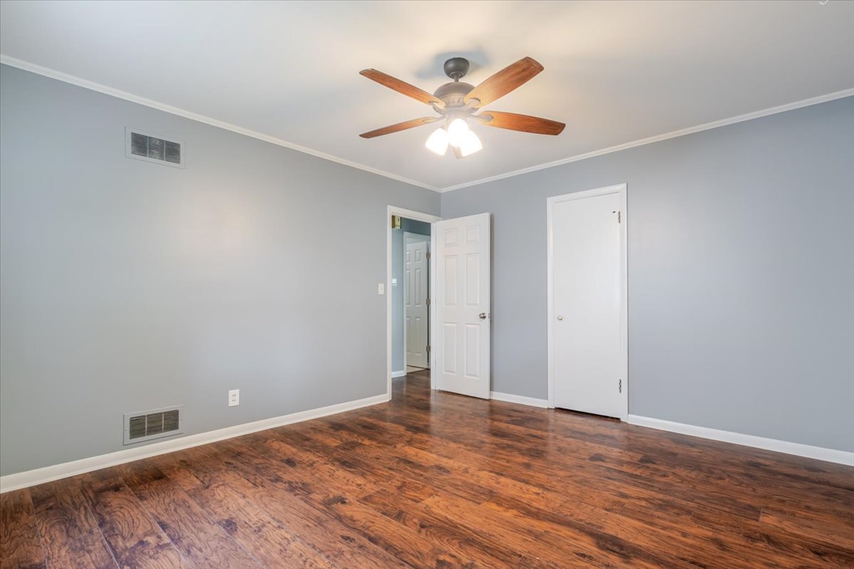 307 Meadows Avenue Bloomington, IL 61701 - Photo 10 of 15 a view of an empty room with wooden floor and a ceiling fan