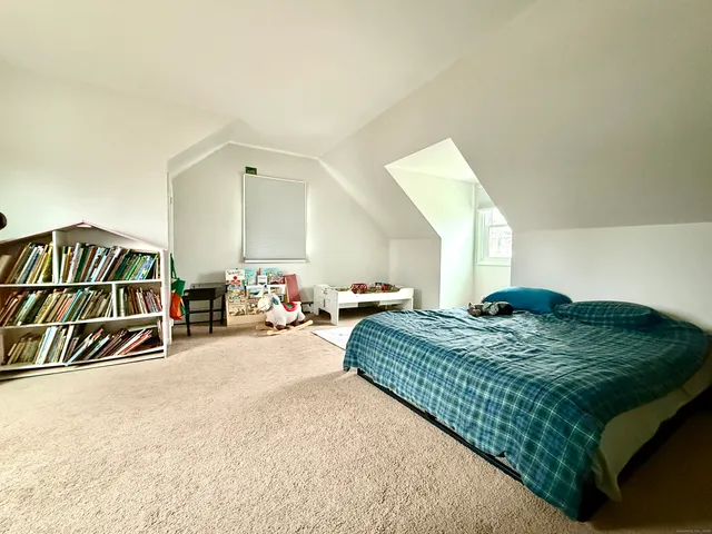 a bedroom with bed and a large window