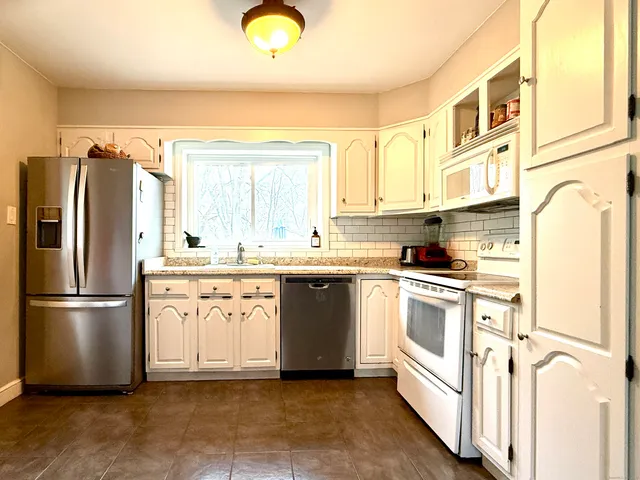 a kitchen with stainless steel appliances granite countertop a refrigerator and a stove top oven