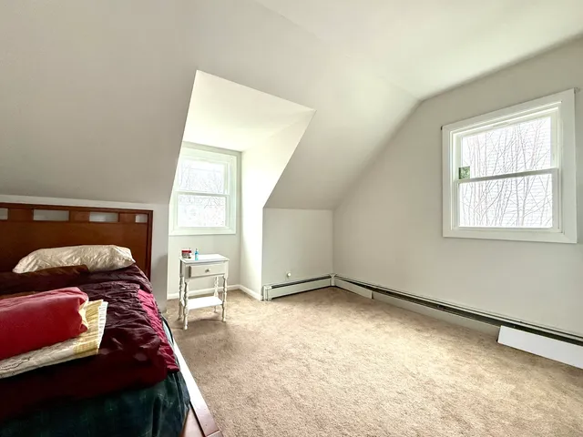 a bed sitting in a bedroom next to a window