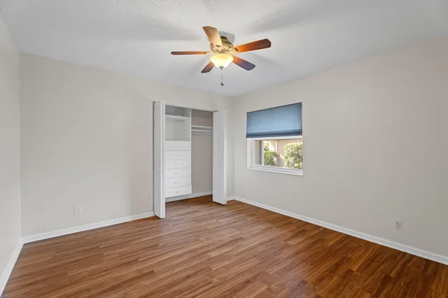 a bathroom with a granite countertop double vanity sink a mirror and a shower