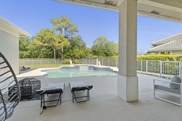 a view of a swimming pool with a lawn chairs under an umbrella