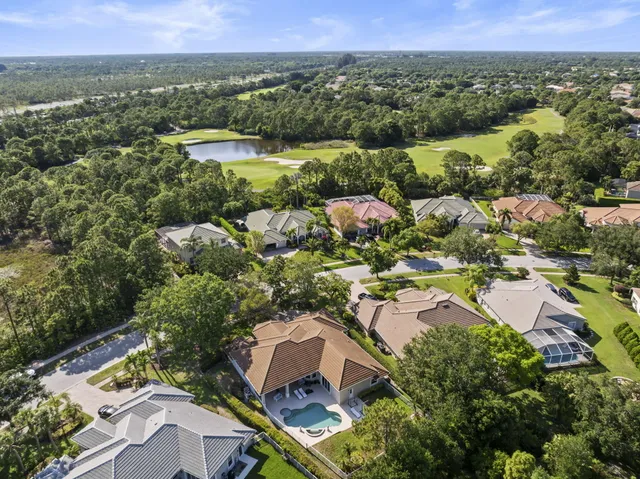 an aerial view of residential houses with outdoor space and trees