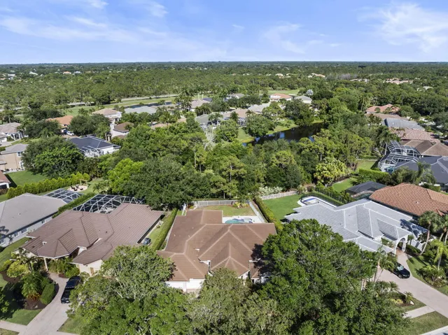 an aerial view of residential houses with outdoor space and trees