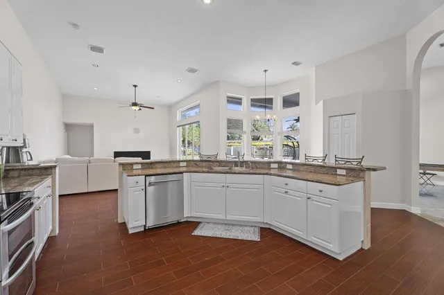 a kitchen with stainless steel appliances granite countertop a stove top oven a sink a counter space and cabinets