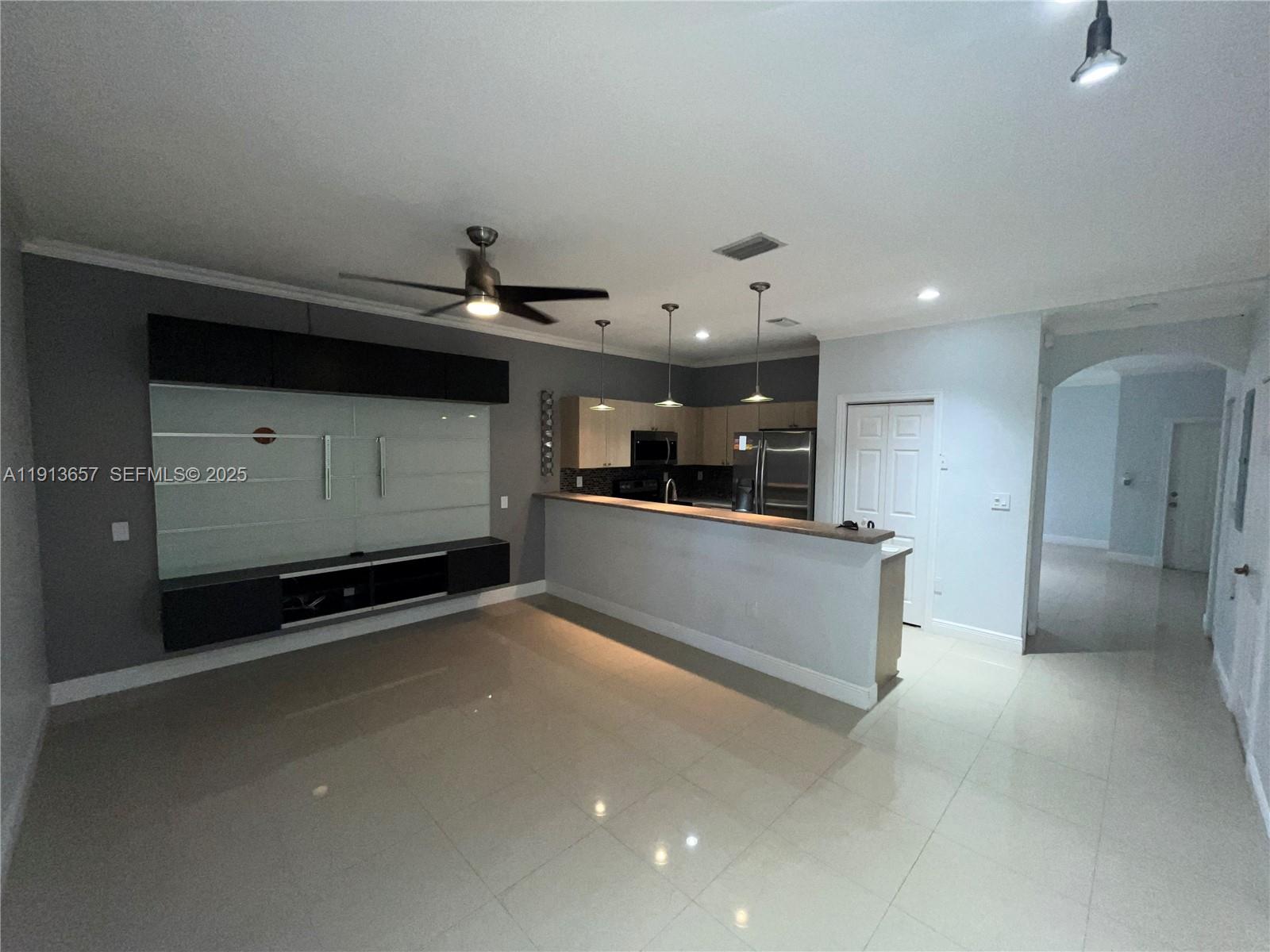 4929 Southwest 140th Terrace, Unit 5 Miramar, FL 33027 - Photo 13 of 43 a living room with stainless steel appliances kitchen island a sink and a refrigerator