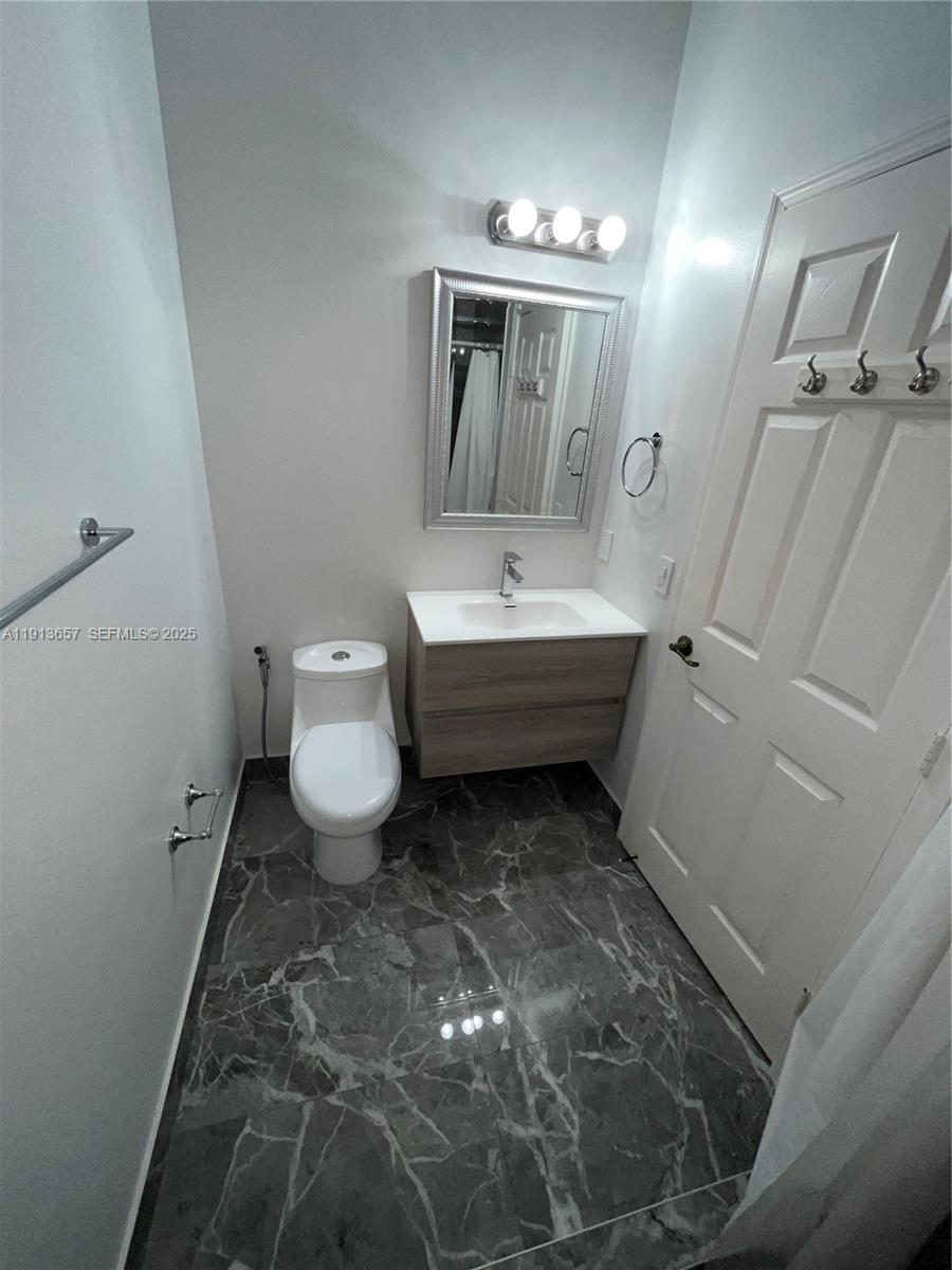 4929 Southwest 140th Terrace, Unit 5 Miramar, FL 33027 - Photo 28 of 43 a bathroom with a toilet sink and mirror