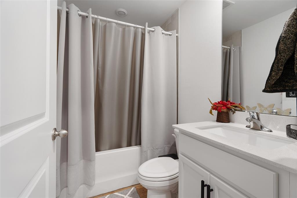 1304 Goshen Road North Port, FL 34288 - Photo 22 of 39 a bathroom with a sink a toilet a mirror and shower curtain