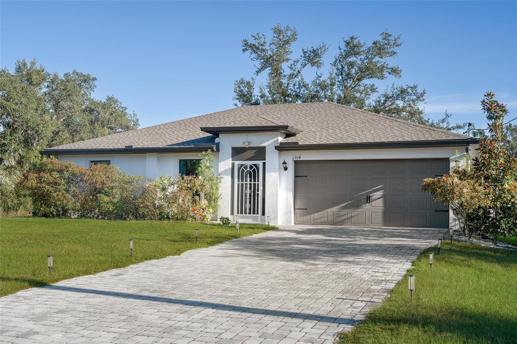 1304 Goshen Road North Port, FL 34288 - Photo 26 of 39 a front view of a house with a garden and yard