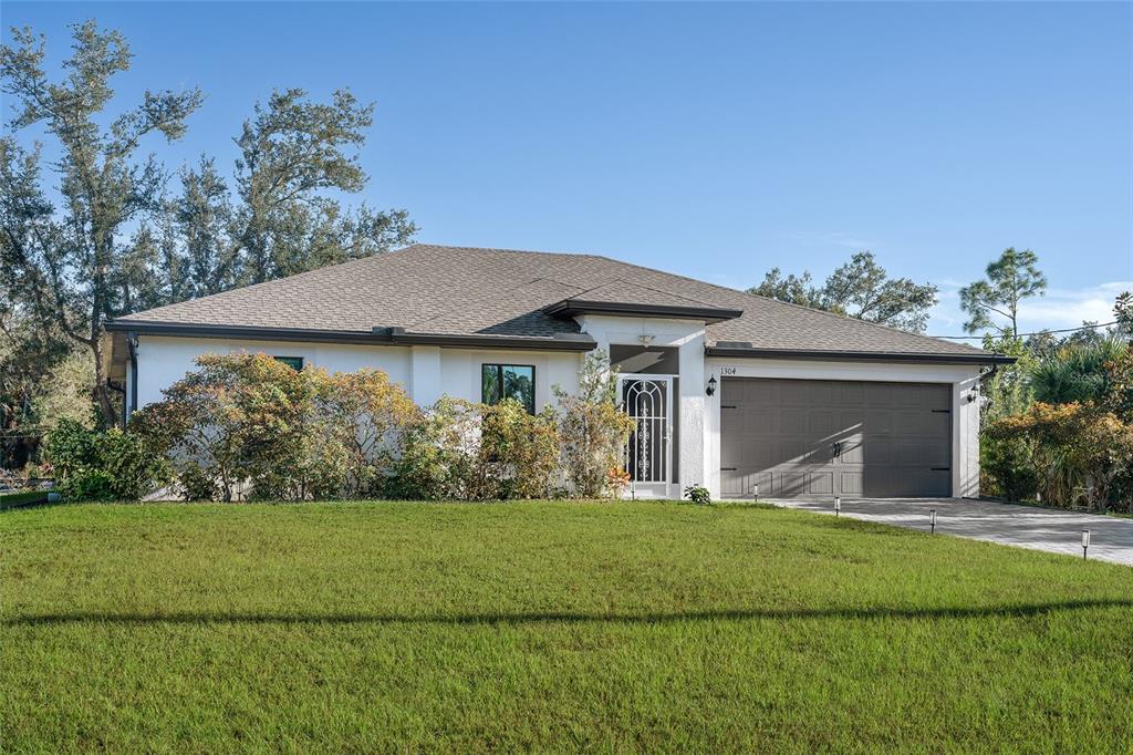 1304 Goshen Road North Port, FL 34288 - Photo 27 of 39 a front view of a house with a garden and yard