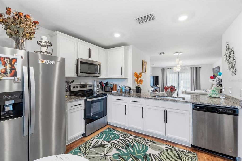 1304 Goshen Road North Port, FL 34288 - Photo 3 of 39 a kitchen with granite countertop a sink stainless steel appliances and white cabinets