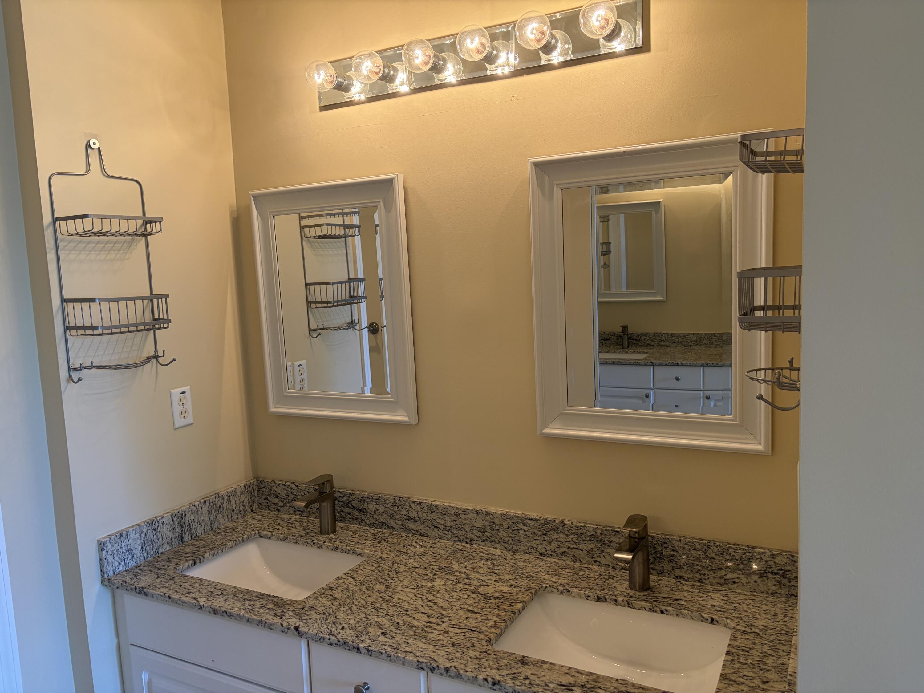 27 Royal Palm Way, Unit 304 Boca Raton, FL 33432 - Photo 11 of 26 a bathroom with a granite countertop sink and a mirror