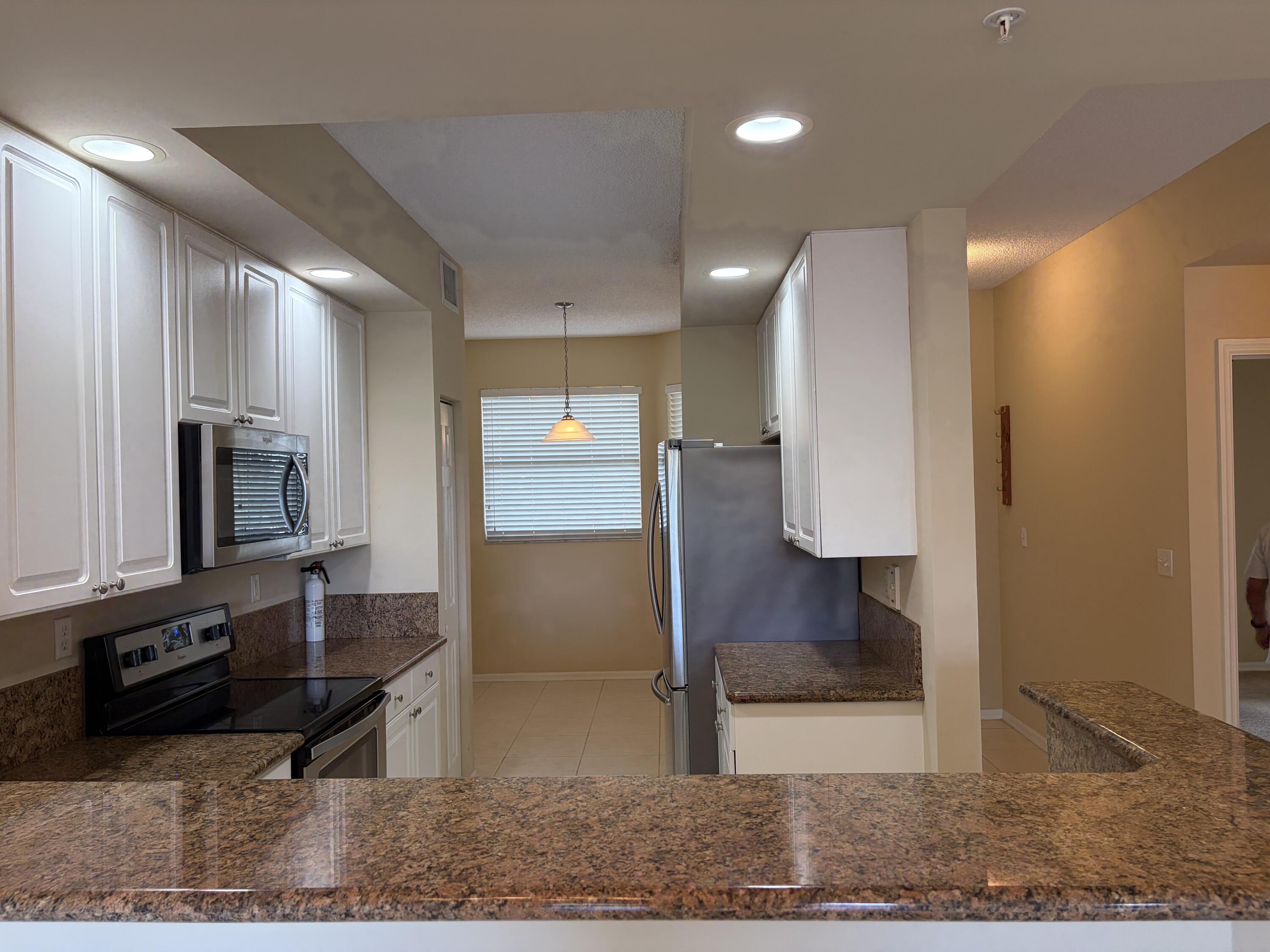 27 Royal Palm Way, Unit 304 Boca Raton, FL 33432 - Photo 2 of 26 a kitchen with stainless steel appliances kitchen island granite countertop a refrigerator and a stove