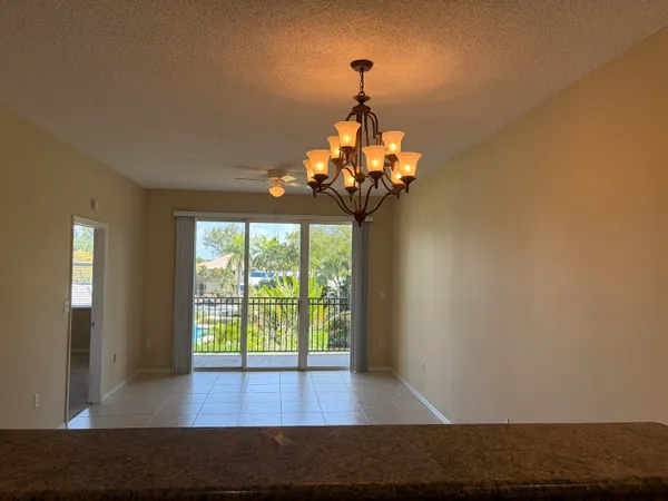 a view of a livingroom with a chandelier wooden floor and a chandelier