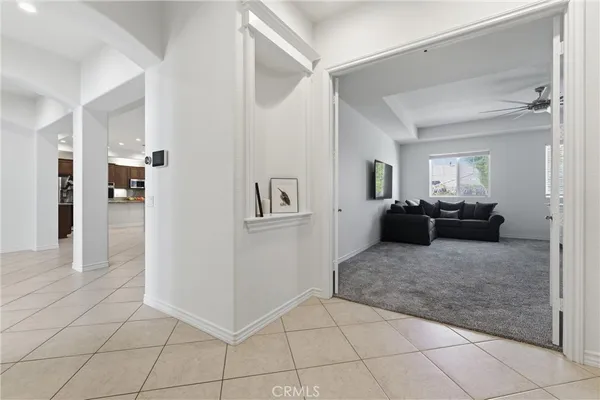 a living room with furniture and a refrigerator