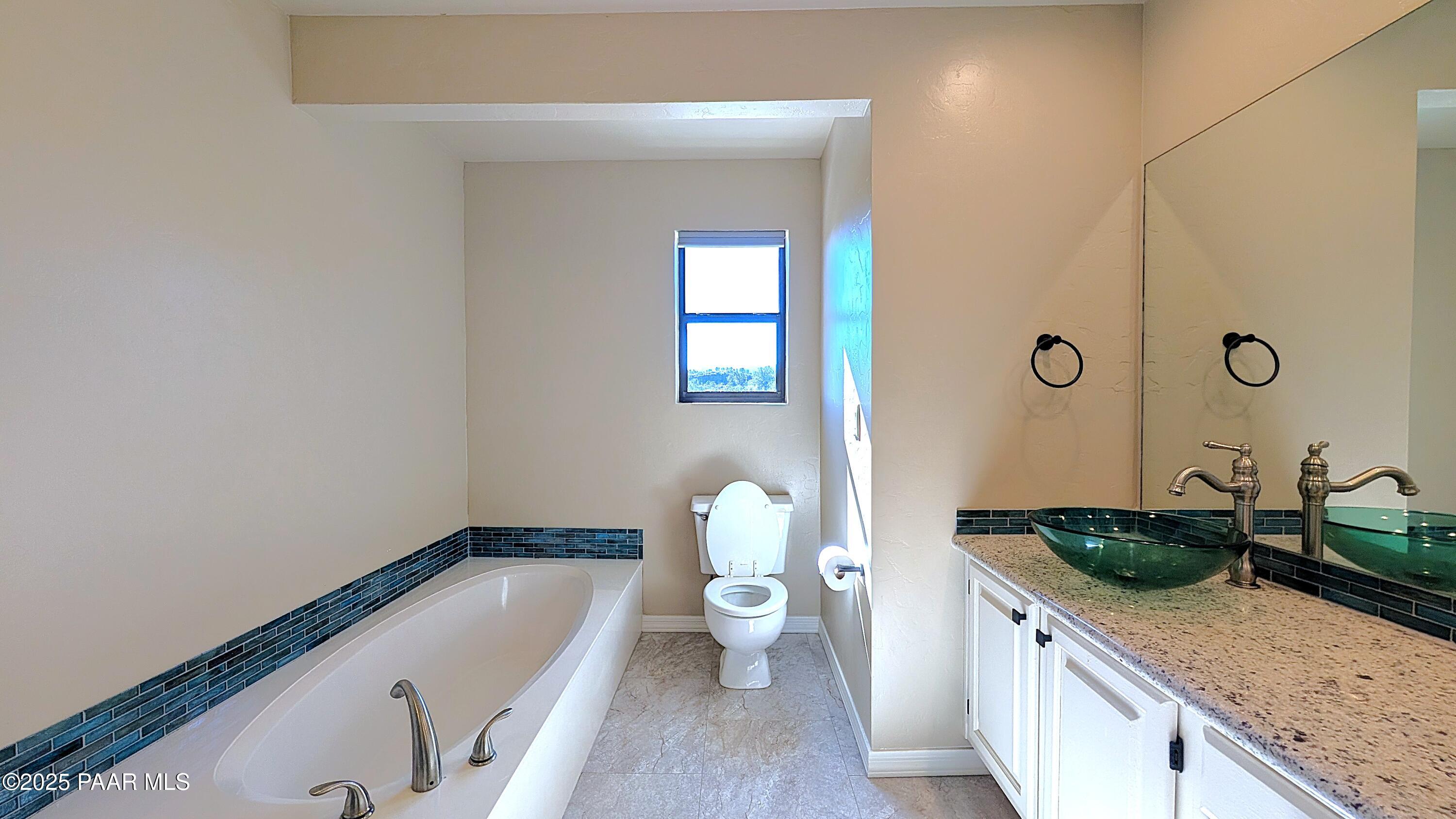 4911 Hornet Drive Prescott, AZ 86301 - Photo 13 of 29 a bathroom with a granite countertop tub a sink and a large mirror