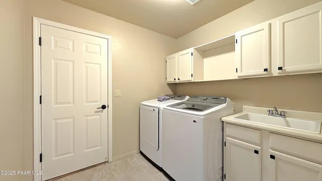 a utility room with sink dryer and washer