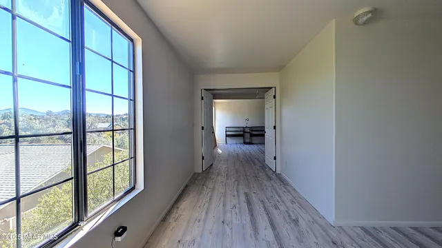 a view of a hallway with wooden floor and furniture