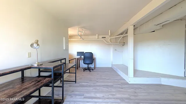 a view of a workspace with furniture and wooden floor