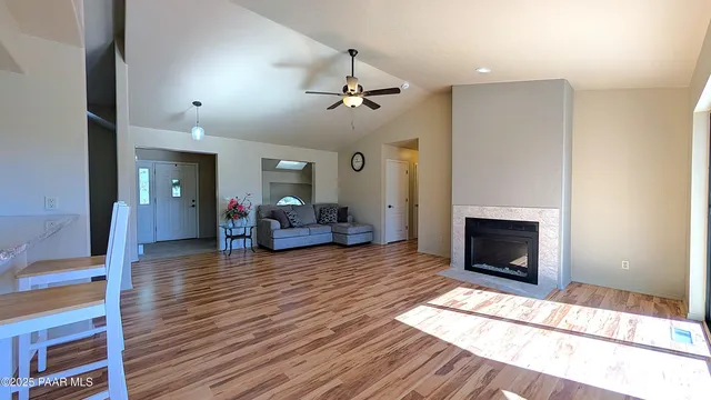 a living room with furniture a fireplace and wooden floor