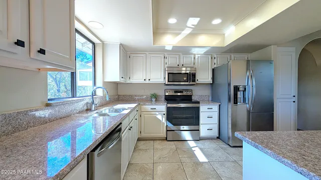 a kitchen with stainless steel appliances granite countertop a sink stove and refrigerator