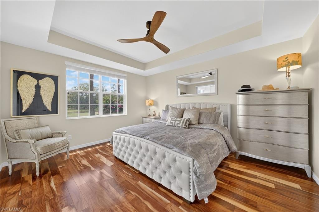 1940 Willow Bend Circle, Unit 102 Naples, FL 34109 - Photo 11 of 39 a bedroom with a bed and wooden floor