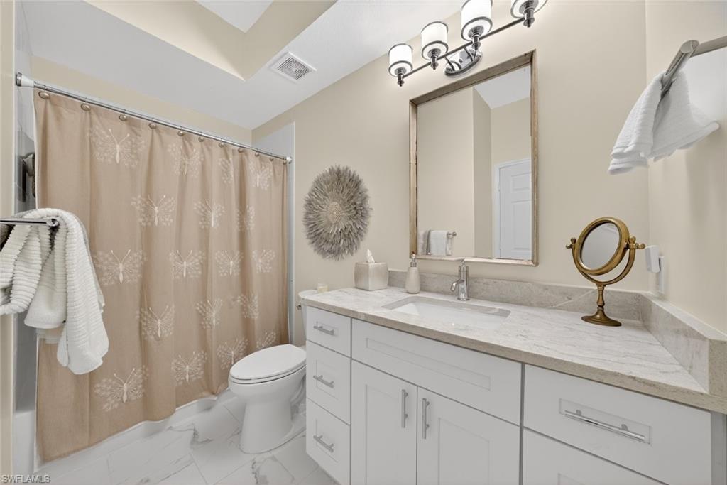 1940 Willow Bend Circle, Unit 102 Naples, FL 34109 - Photo 16 of 39 a bathroom with a sink vanity granite and a mirror