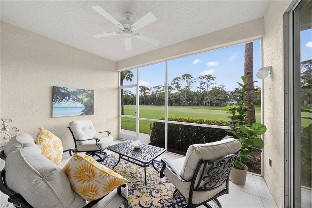 1940 Willow Bend Circle, Unit 102 Naples, FL 34109 - Photo 17 of 39 a living room with furniture and a floor to ceiling window