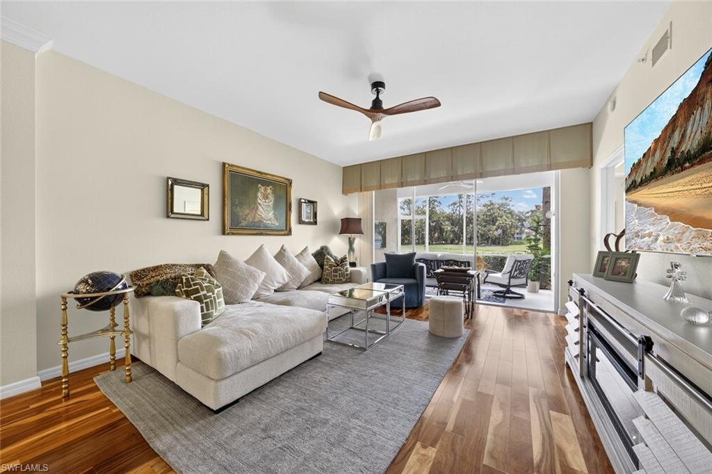 1940 Willow Bend Circle, Unit 102 Naples, FL 34109 - Photo 2 of 39 a living room with furniture and a floor to ceiling window