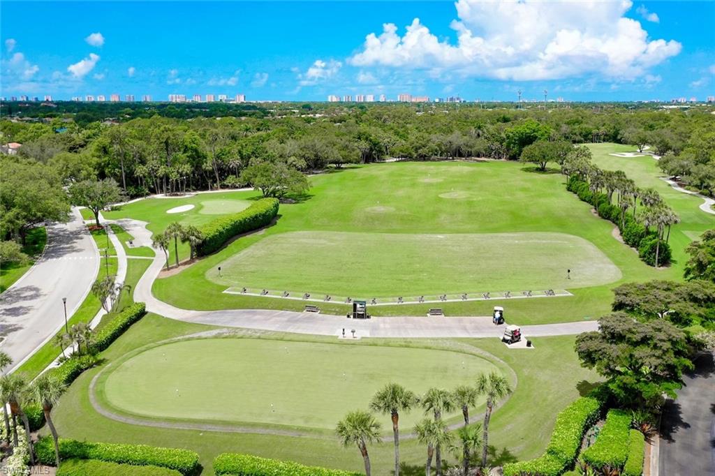 1940 Willow Bend Circle, Unit 102 Naples, FL 34109 - Photo 31 of 39 a view of a swimming pool with a yard