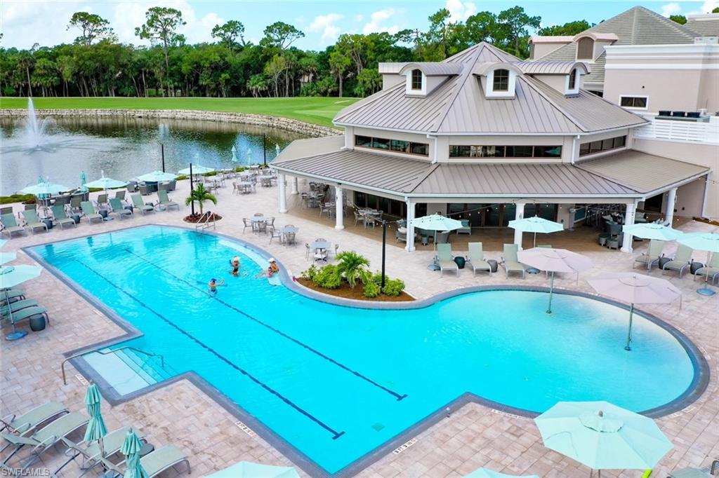 1940 Willow Bend Circle, Unit 102 Naples, FL 34109 - Photo 34 of 39 a view of a swimming pool with lounge chairs in the patio