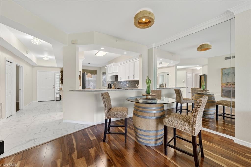1940 Willow Bend Circle, Unit 102 Naples, FL 34109 - Photo 9 of 39 a view of a dining room with furniture and wooden floor