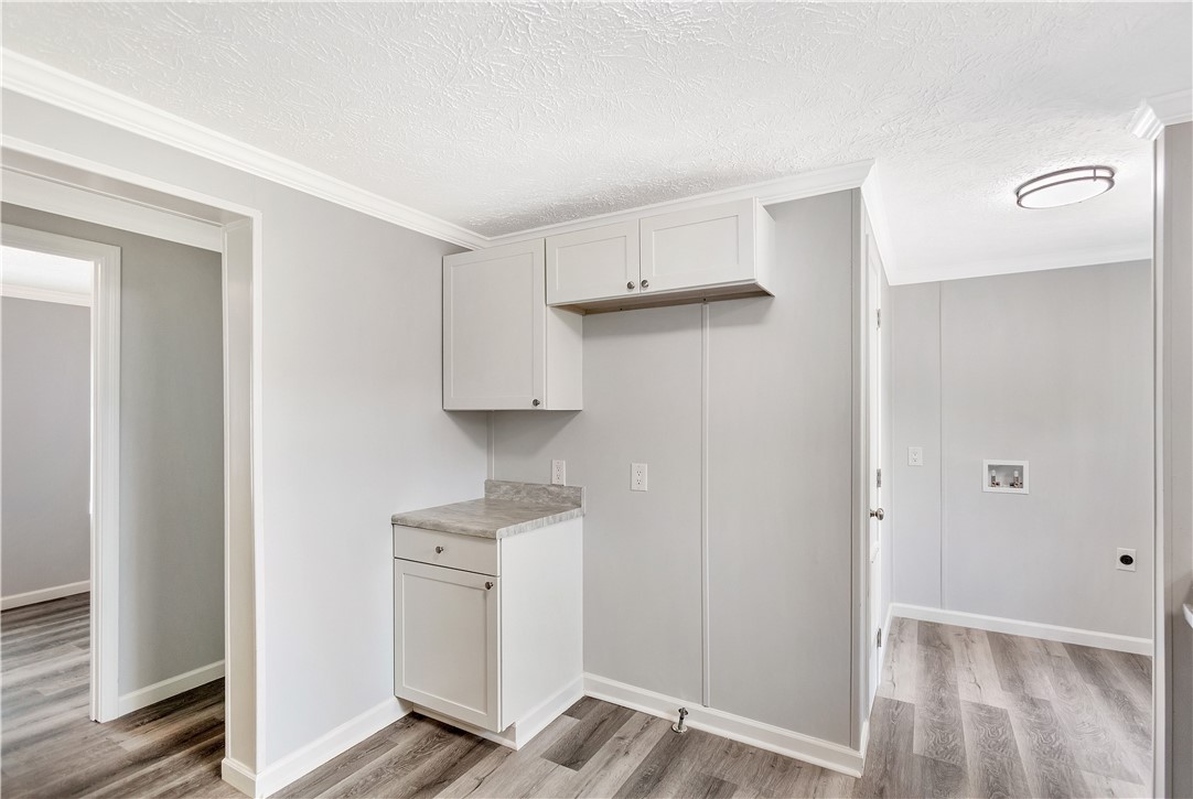 403 Hancox Place Westminster, SC 29693 - Photo 18 of 39 Functional laundry space featuring ample cabinet storage and durable laminate flooring.