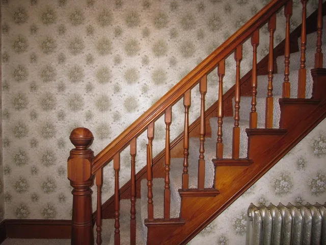 a view of staircase with lots of frames on wall and a large window