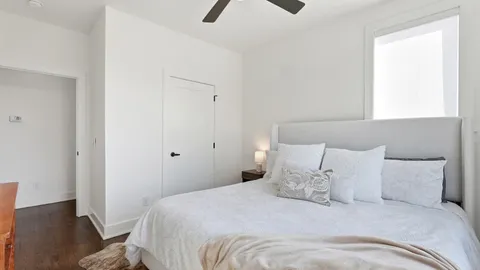 a large bed in a bedroom next to a window